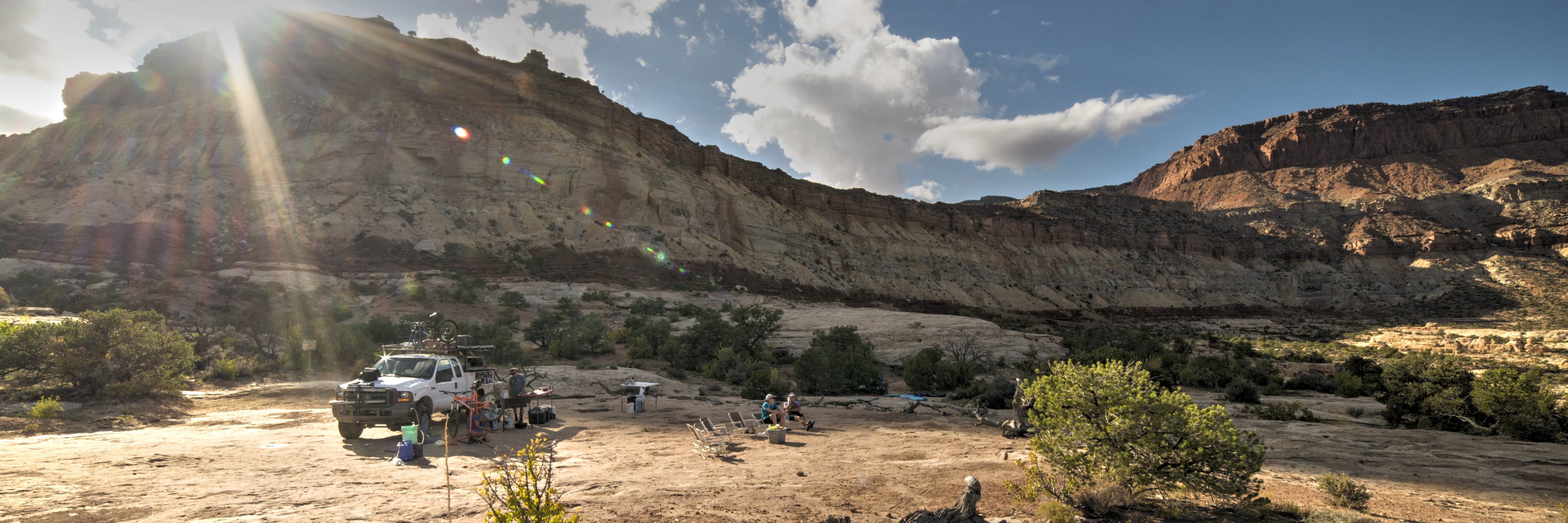 The sun sets behind Teapot Rock in The Maze, Canyonlands NP, as guides prepare dinner and guests relax after a full day's ride
